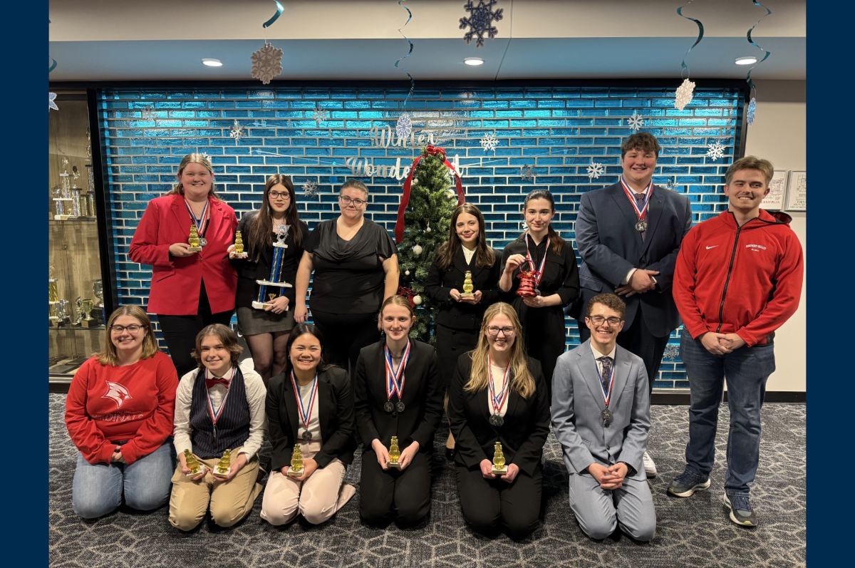 group of students in front of bright blue tile wall